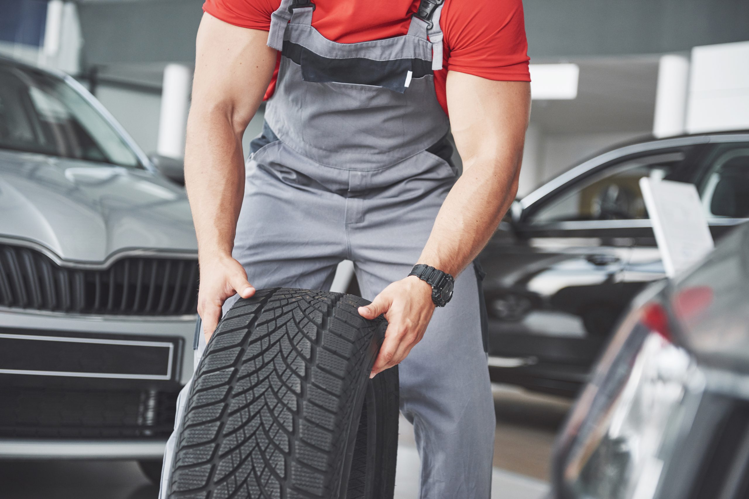 Mechanic holding a tire tire at the repair garage. replacement of winter and summer tires.